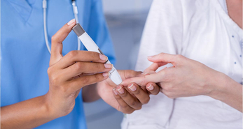 Nurse examining a pregnant patient's blood glucose